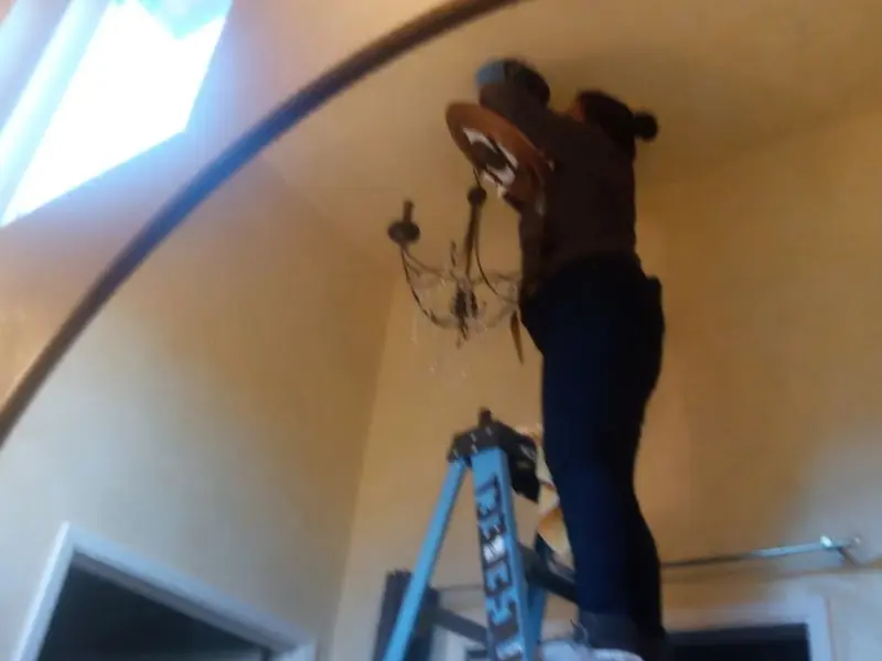 Electrician installing a chandelier in a LaGrange residence